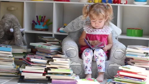 Toddler girl reading books Stock Footage