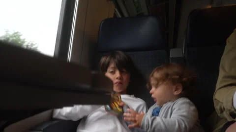 Toddler grabbing object beside older brother during passenger train journey.. Stock Footage 338122348