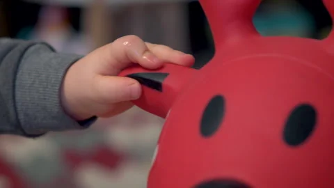 Toddler Hand Holding Ear Of Red Rubber Bouncy Animal Toy And Letting Go Stock Footage 330708689