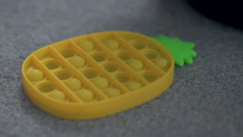 Toddler Hand Pushing A Bubble On Yellow Pineapple Sensory Fidget Toy Stock Footage 330707904