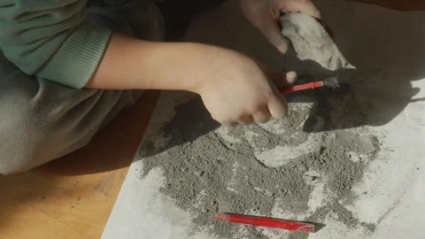 Toddler hands doing science experiment - fossil digging Stock Footage 260371068