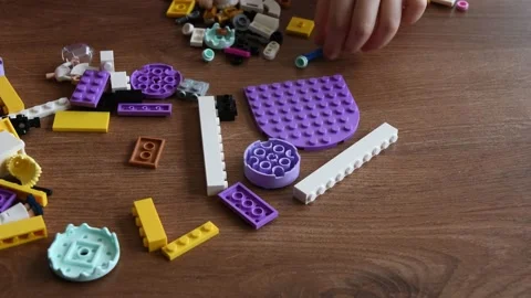 Toddler hands takes tiny Lego bricks and toys while playing Lego games Video stock 149836856