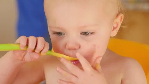 Toddler Happily Eats Apple Sauce On His Own Stock Footage 77372502