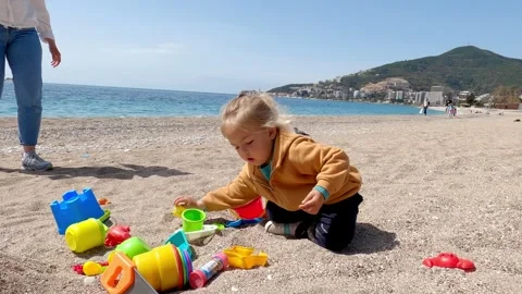 Toddler having fun playing in the sand by the water at the beach Stock Footage 284831003