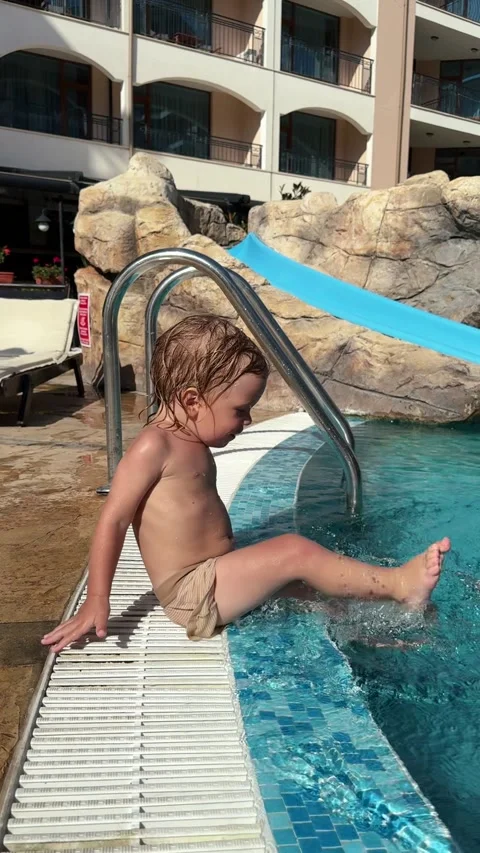 Toddler Having Fun by the Poolside at a Sunny Resort Stock Footage 345495678