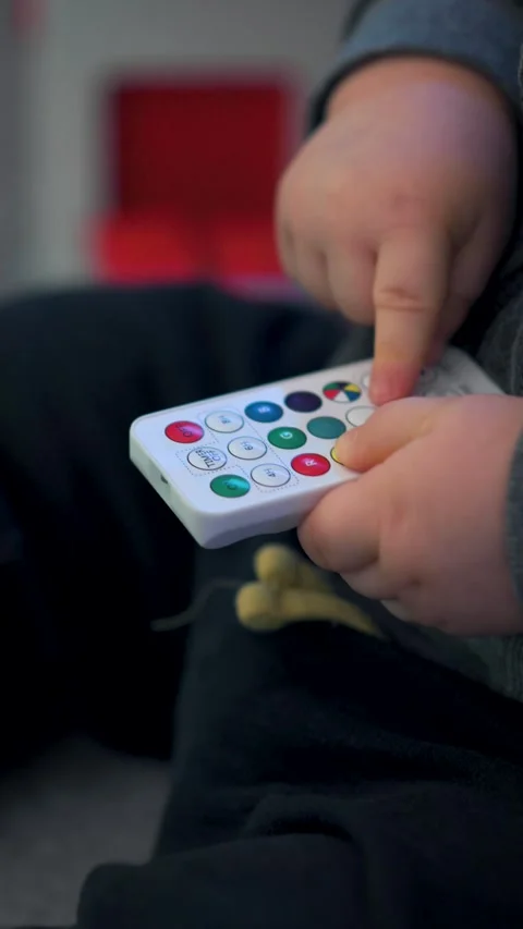 Toddler Holding Small White Remote: Vertical Close-Up Stock Footage 325131407
