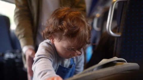 Toddler holding stroller while traveling by train with family, highlighting.. Stock Footage 338123280