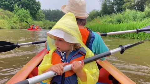 Toddler holds the scull while sitting in the kayak Stock Footage 279503422