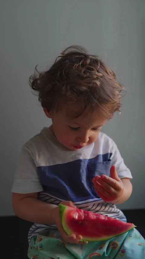 Toddler inspecting watermelon seeds before taking bite showing curiosity se.. Stock Footage 337038521