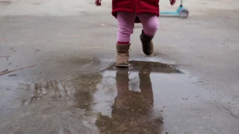 Toddler Jumping and Dancing in Puddles on Rainy Day Stock Footage 83866967