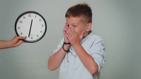 Toddler kid boy with anxiety checking time on clock, running late to work, being Stock Footage 204050178