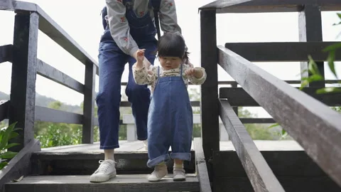 Toddler kid learning to walk is going down stairs Stock Footage 205865478