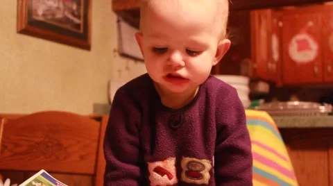 Toddler leans on table looking down Vídeos de archivo 45706503