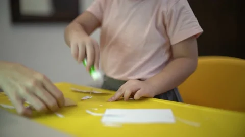 Toddler learning to use glue for her jellyfish creation Stock Footage 159056734