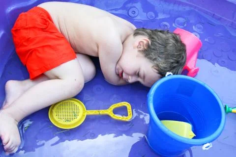 Toddler lying down in a pool Stock Photos