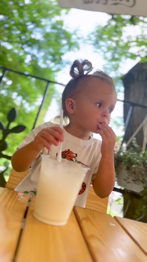 Toddler making bubbles in drink with straw Stock Footage 315203202