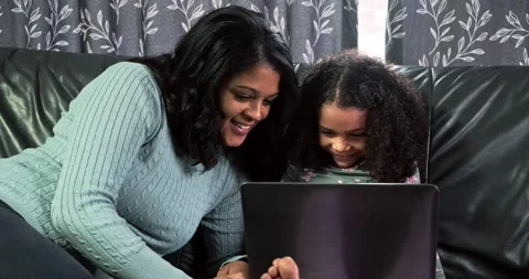 Toddler, mom sitting on couch using laptop. Smiling and looking. Stock Footage 319066773