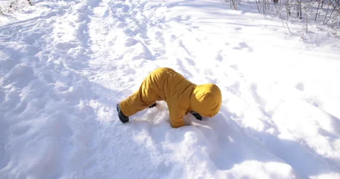 Toddler in parka awkardly getting up in the snow Stock Footage 149076044