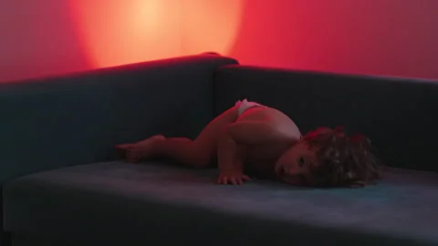 Toddler playfully falling into couch from armrest, highlighting fearless ex.. Stock Footage 340427444