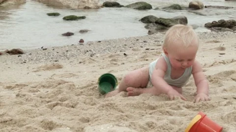 Toddler playing with a bucket and spade at the beach.mov Stock Footage 59100662