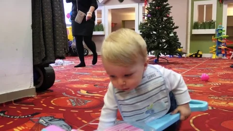 Toddler playing in a floor - Christmas tree on background Stock Footage 83754904