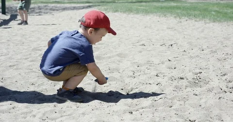 Toddler playing by him self in the sand at park - slow motion Video stock 91730008