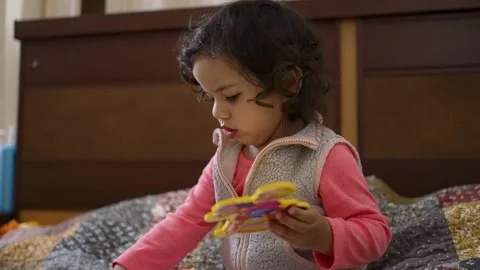 Toddler Playing with an Interactive Book on a Bed Video stock 306732311