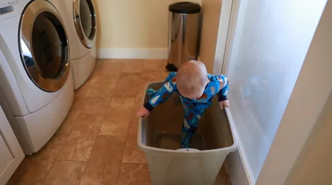 A toddler playing in the laundry room Stock Footage 33310695