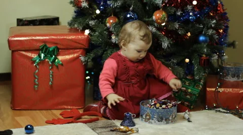 Toddler playing next to a Christmas tree Stock Footage 57647429