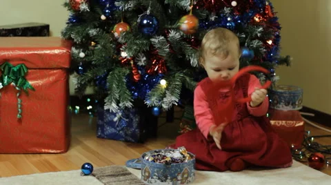 Toddler playing next to a Christmas tree Stock Footage 57647557