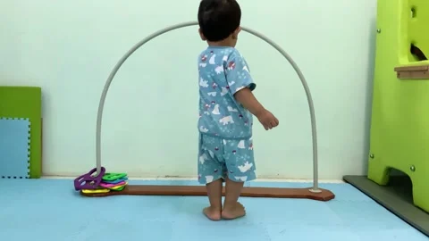 Toddler Playing with Toy Sliding Ring Arch in Home Setting Stock Footage 341914239