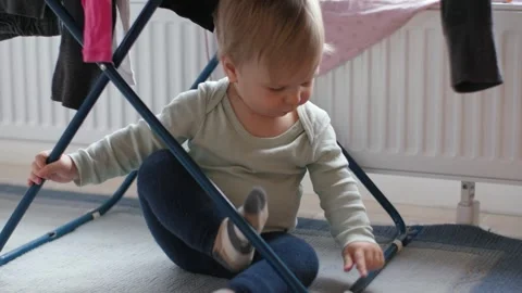 Toddler Playing Underneath Drying Rack Stock Footage 303498708