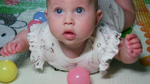 Toddler in a playpen. Drool is running down the ball. Vídeos de archivo 337511192