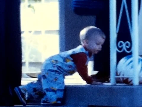 Toddler plays in front of house Stock Footage 78010627