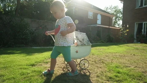 Toddler pulling a pram Video stock 94518386