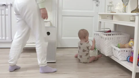 Toddler pulls the electric plug out of socket, 1 year old infant playing with Stock Footage 171986595