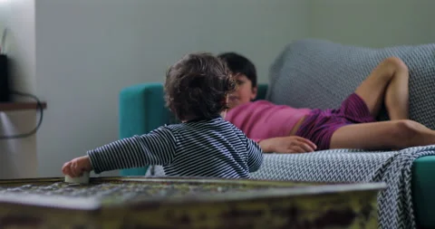 Toddler reaches from coffee table toward sofa and attempts first steps at h.. Stock Footage 340975889