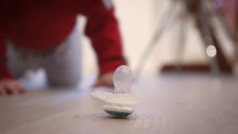 A toddler reaches for his pacifier Stock Footage 203974331