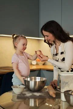 Toddler Reaching for Egg from Mother While Baking Stock-Fotos