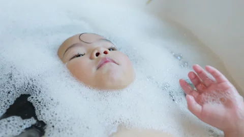 Toddler relaxes in a bubble bath Stock Footage 339047592