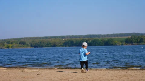 Toddler running to the river by the sandy beach.  Stock Footage 268604553