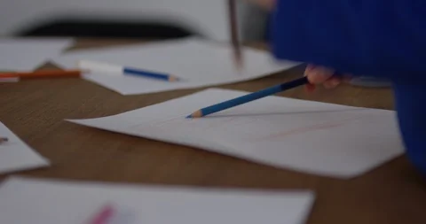 Toddler scribbles on paper with colored pencil - extreme close up - shallow d Video stock 88957953