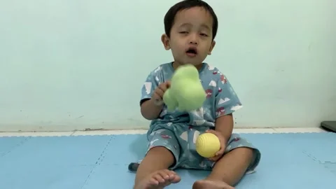 Toddler Sitting and Playing with Plush Toys on Floor Stock Footage 341914385