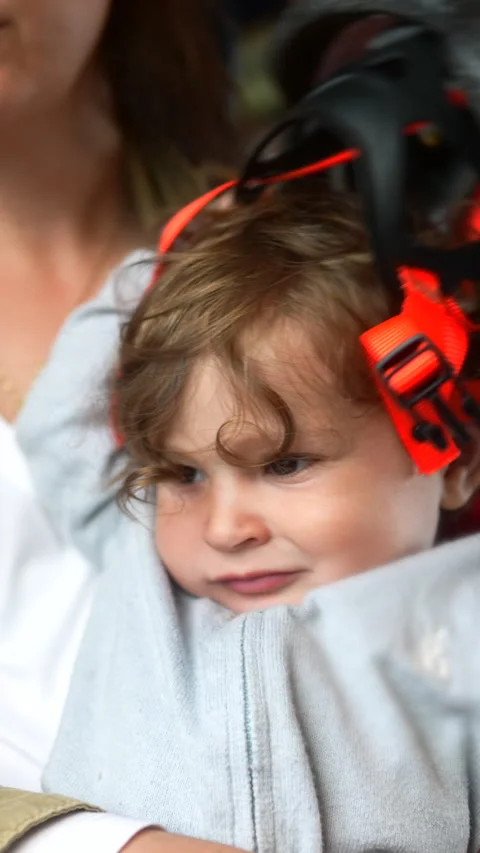 Toddler sitting on mothers lap while putting on bicycle helmet during train.. Stock Footage 338138444