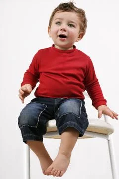 Toddler sitting on a stool Foto stock