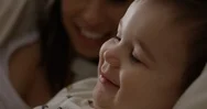 Toddler Spits As He Laughs While Reading A Book With His Mom - Slow Motion Stock Footage