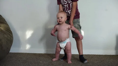 Toddler standing for the first time and falling Stock Footage 95358235