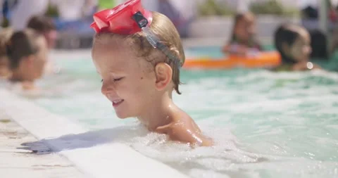 Toddler swimming in pool with red goggles Stock Footage 307755705