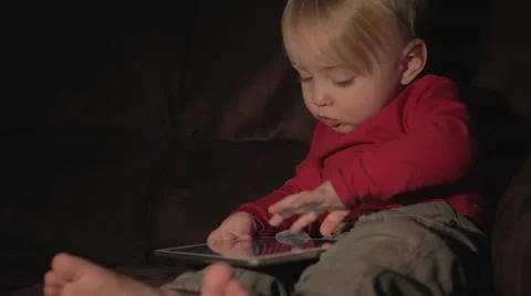 A toddler with a tablet computer on the couch Stock Footage 59121173