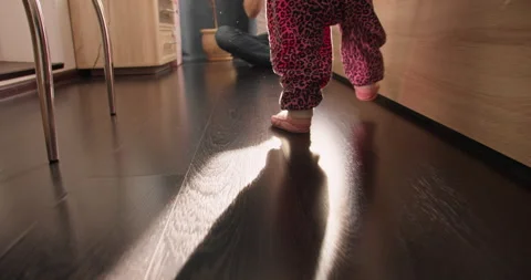 Toddler taking first steps with father nearby Stock Footage 336814650